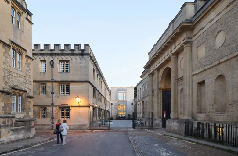 Corpus Christi College Oriel square with 2 people walking