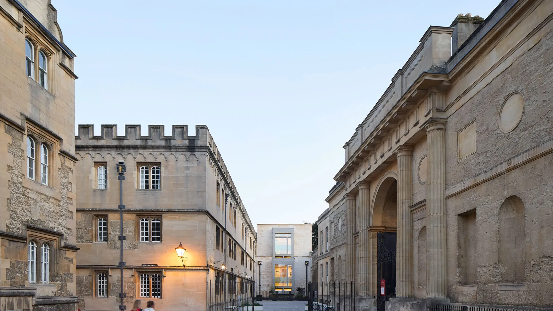 Corpus Christi College Oriel square with 2 people walking