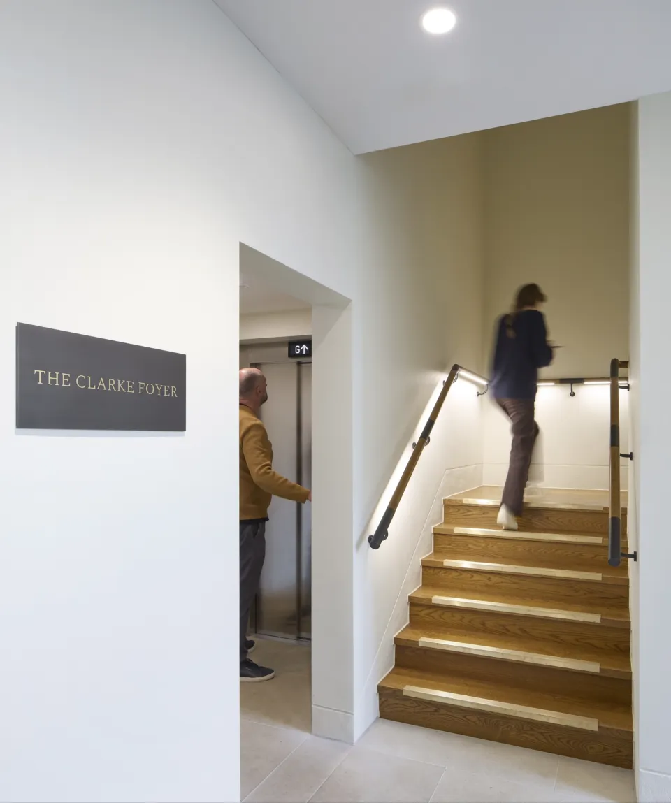 Corpus Christi Spencer Building Lift with one man waiting for the lift and one girl walking up the stairs