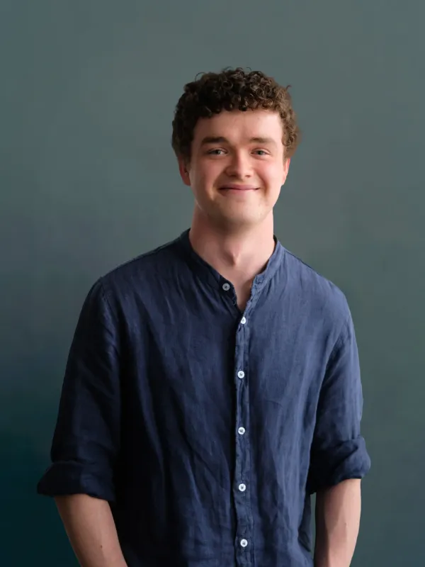 Headshot of a man with brown hair and a blue shirt